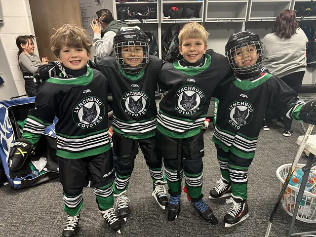 Four Mites teammates in Coyotes jerseys, arms over shoulders in the locker room
