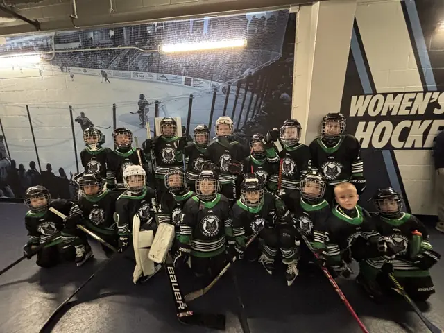 The full Mites team gathered for a group photo in front of the rink mural