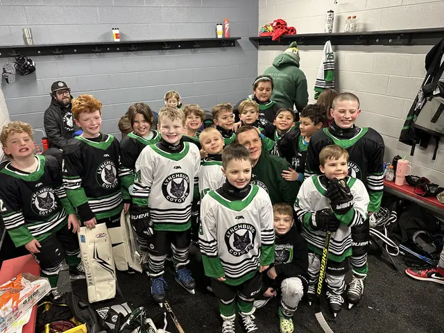 The whole team packed into the locker room after a game, grinning
